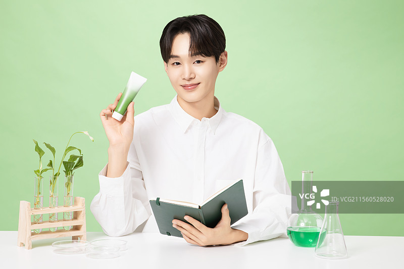 一位年轻男子与植物制作的基础化妆品摆姿势图片素材