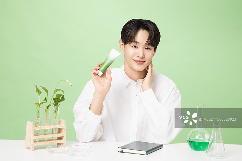 一位年轻男子与植物制作的基础化妆品摆姿势图片素材