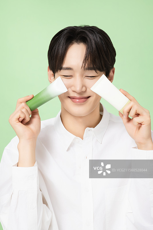 一位年轻男子与植物制作的基础化妆品摆姿势图片素材