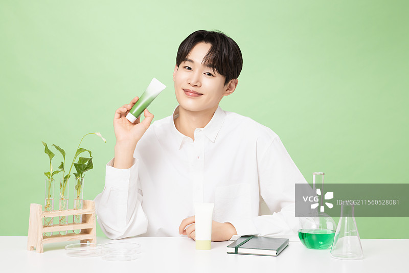 一位年轻男子与植物制作的基础化妆品摆姿势图片素材