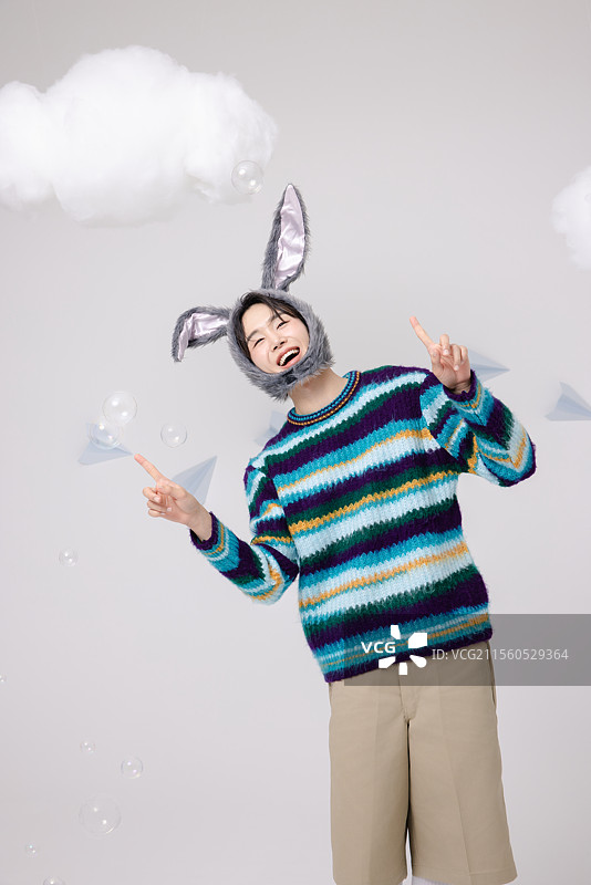 一个戴着兔子帽子并玩泡泡的男人图片素材