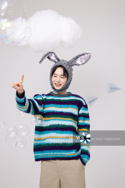 戴着兔子帽子并玩泡泡的男人图片素材
