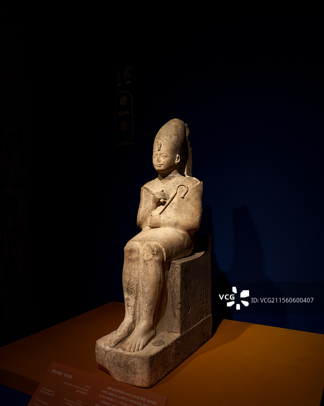 图特摩斯三世坐像（石灰岩）双手抱于胸前握持连枷和权杖，头戴象征上埃及的白冠，两侧展示上下埃及统一场景图片素材