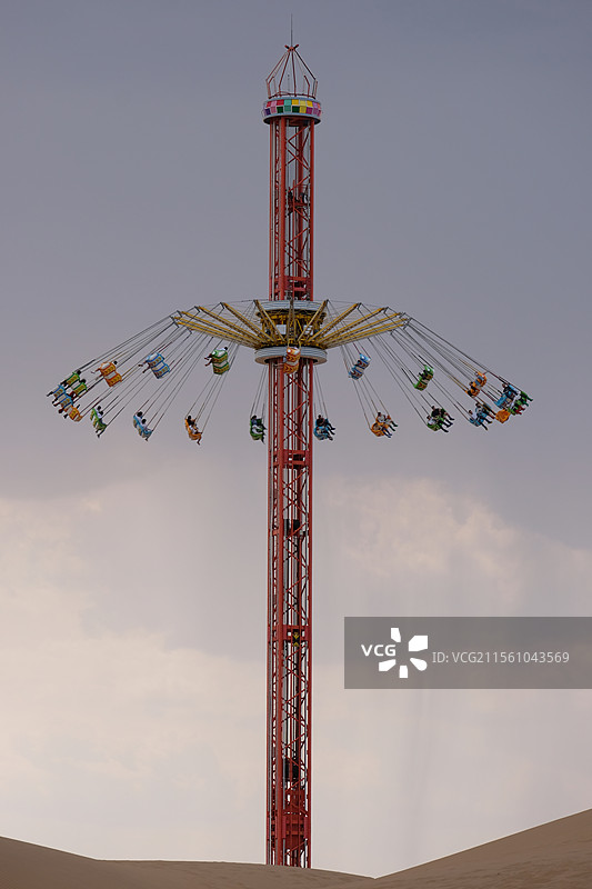 沙漠里的旋转飞椅娱乐设施的低视角图图片素材
