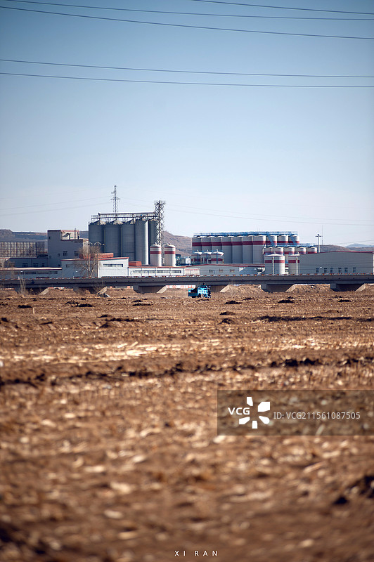 蓝天与黄土地之间劳作的农民。图片素材