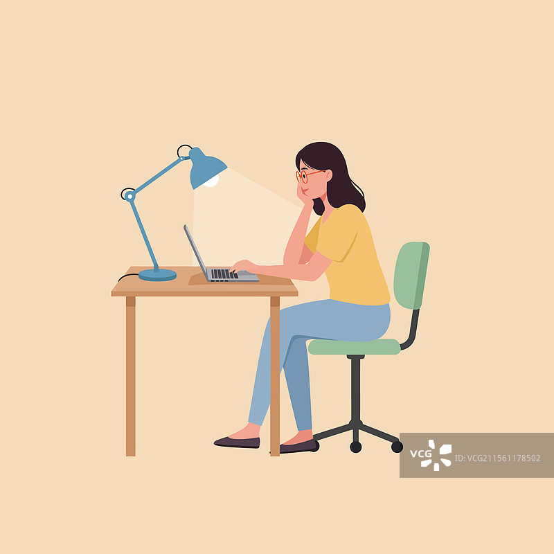女性在桌子上用台灯工作，使用笔记本电脑图片素材