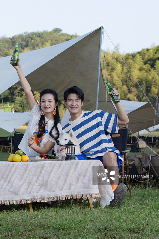 带着宠物狗吃烧烤的年轻情侣图片素材