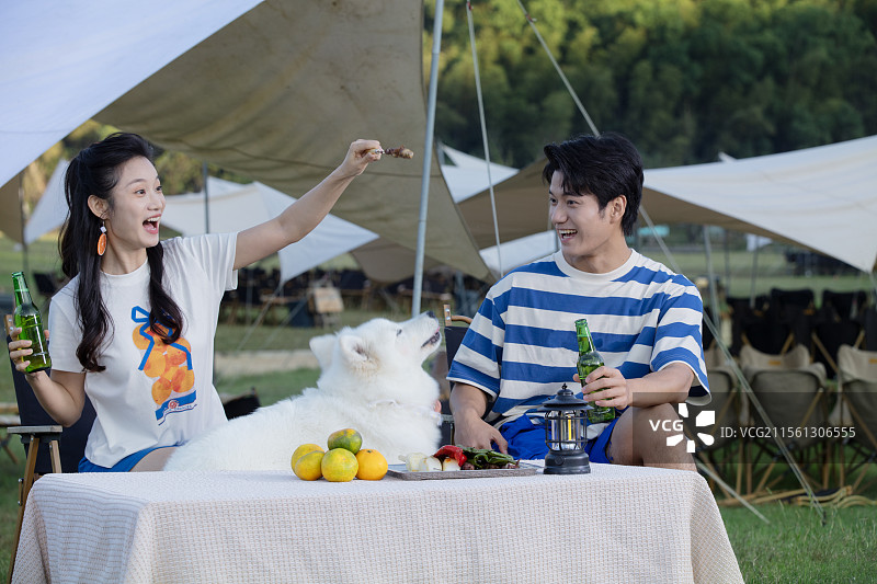 带着宠物狗吃烧烤的年轻情侣图片素材