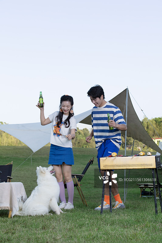 带着宠物狗吃烧烤的年轻情侣图片素材