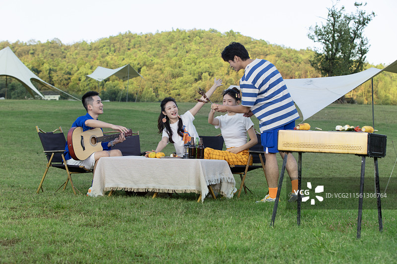 一起烧烤聚会的四个年轻人图片素材