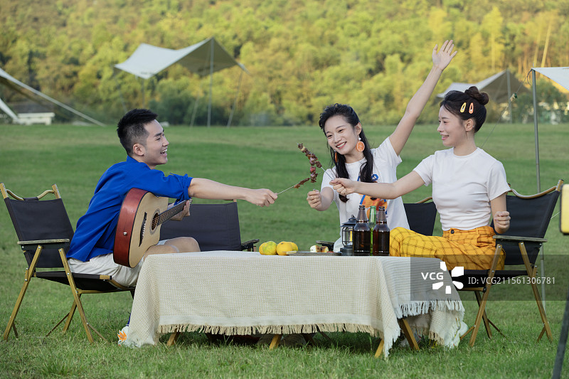 坐在一起吃烧烤的三个青年男女图片素材