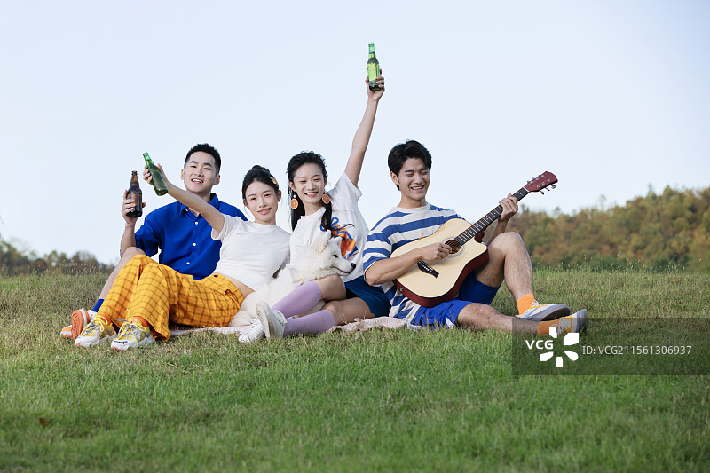 坐在地上喝啤酒的四个年轻人图片素材