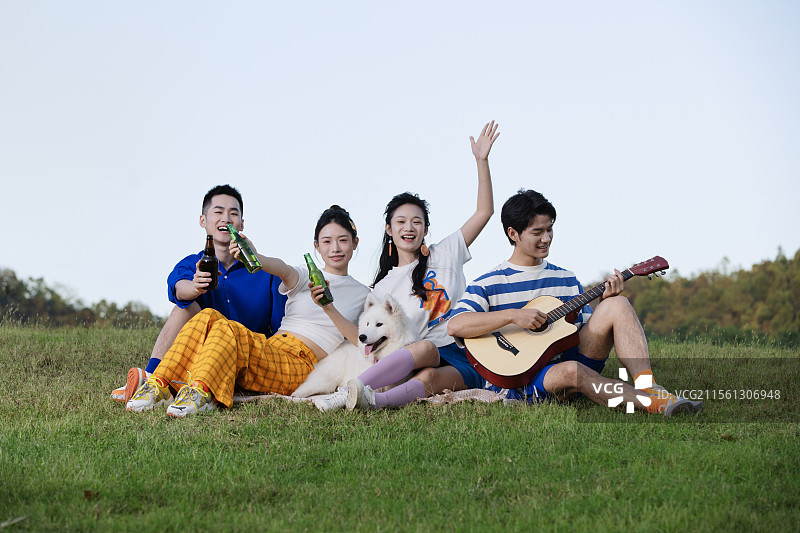 坐在地上喝啤酒的四个年轻人图片素材