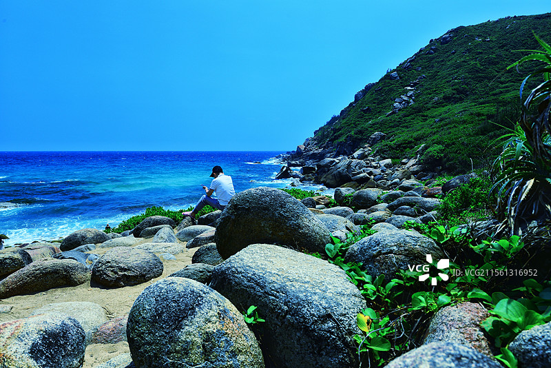 自在！人文纪实。以鹅卵石闻名的海南万宁大花角，是人们休闲的好地方，天蓝水蓝，与大小不一鹅卵石成美景。图片素材
