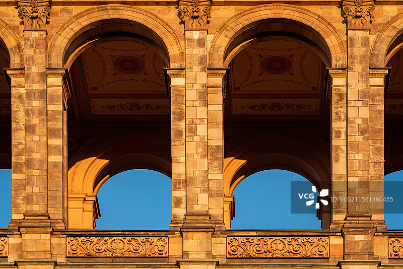 温暖夕阳照射慕尼黑马克西米利安纪念馆,古典建筑拱门在日落暖光中更显精美图片素材