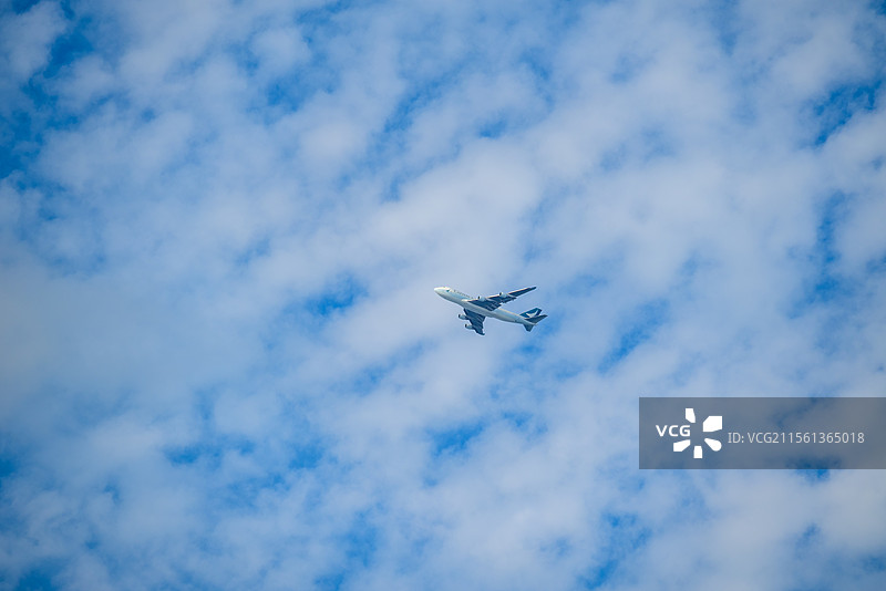 晴朗春日的蓝天白云下飞机穿云而过的地角度视图图片素材