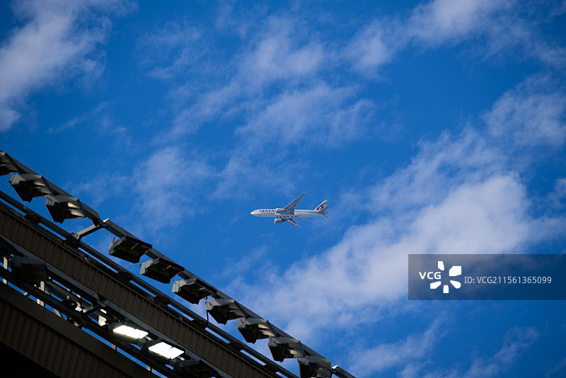 晴朗春日的蓝天白云下飞机穿云而过的地角度视图图片素材