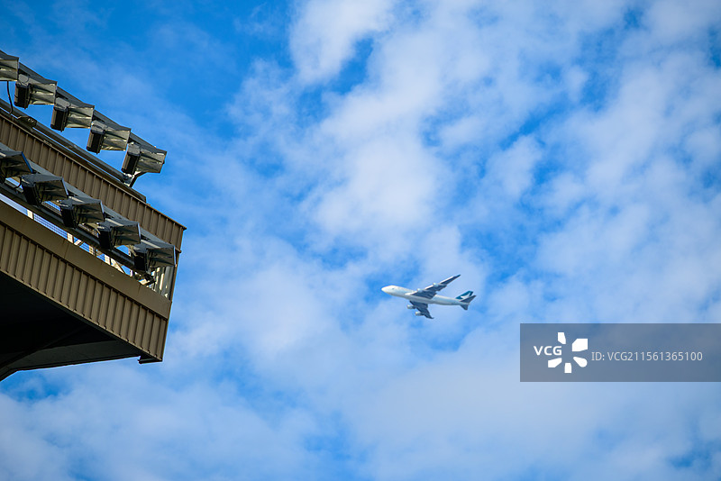 晴朗春日的蓝天白云下飞机穿云而过的地角度视图图片素材