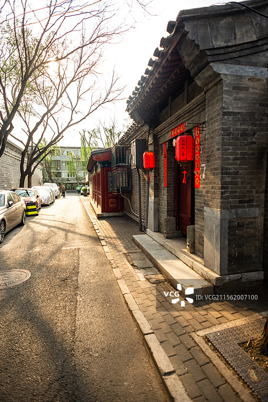 北京大翔凤胡同四合院红色大门街道夕阳行人图片素材