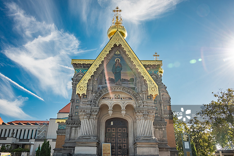 东正教教堂在晴朗的天空下熠熠生辉，金色圆顶和十字架彰显其神圣庄严。复杂装饰和宗教图像展示深厚文化底蕴图片素材