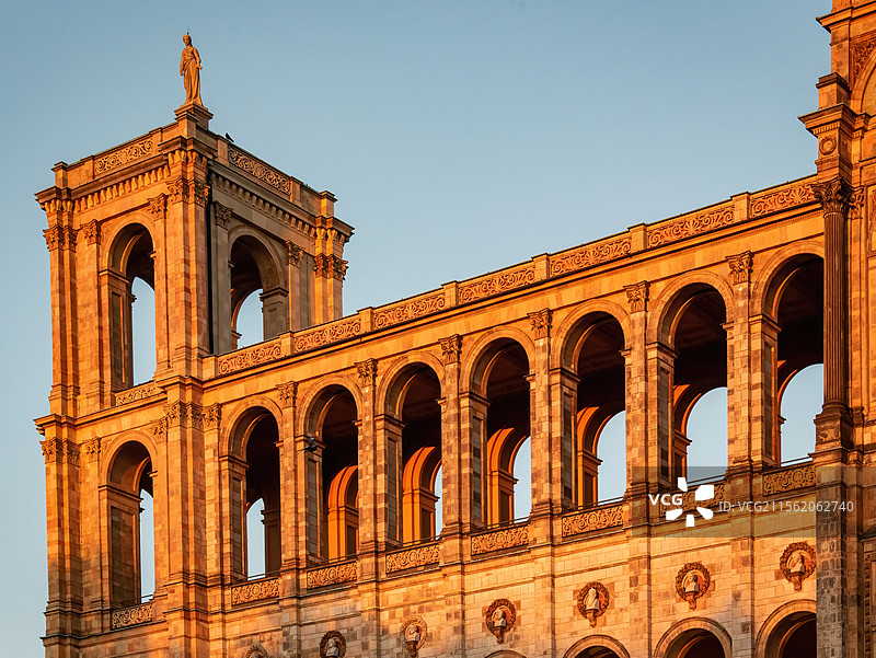 温暖夕阳照射慕尼黑马克西米利安纪念馆显得庄重而神秘，拱门和雕刻装饰细节精致，顶部雕像凝视着远方图片素材