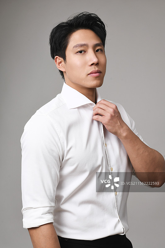 站在灰色背景下的年轻人图片素材