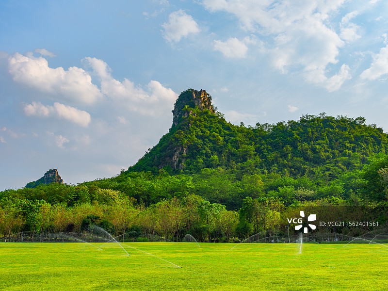 广西柳州马鹿山公园整齐的草地、草坪、青山绿树与蓝天白云风光图片素材