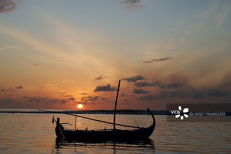 夕阳下海上渔船的剪影图片素材