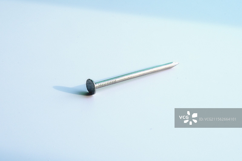 钉子。铁钉。钢钉。金属钉。白色背景下一颗钉子特写图片素材