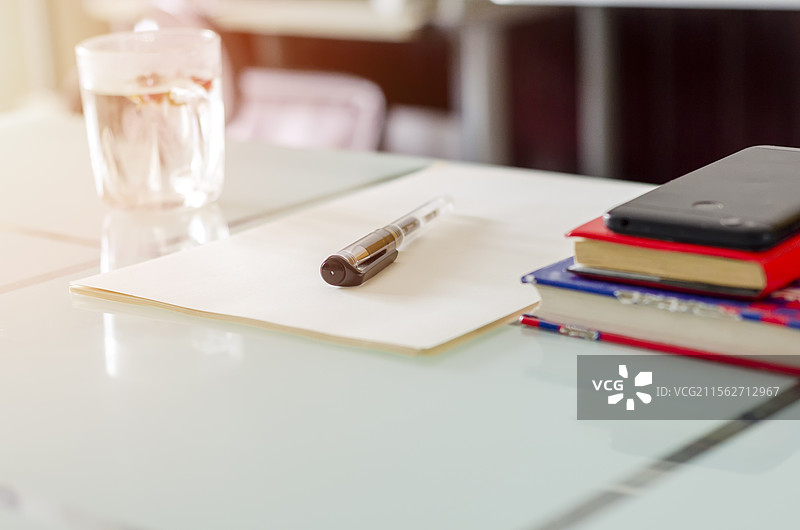 商务咨询工作会议桌上的纸笔和水杯图片素材