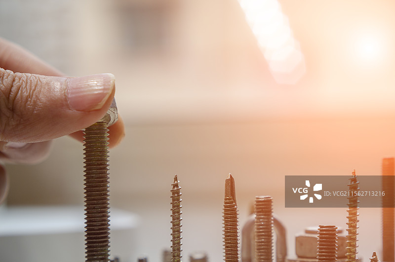 城市建设概念，手指安装螺母特写图片素材