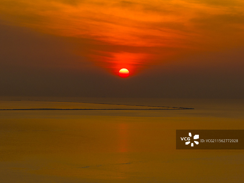 营口鲅鱼圈夕阳下海边沙滩日落夕阳下的大海图片素材