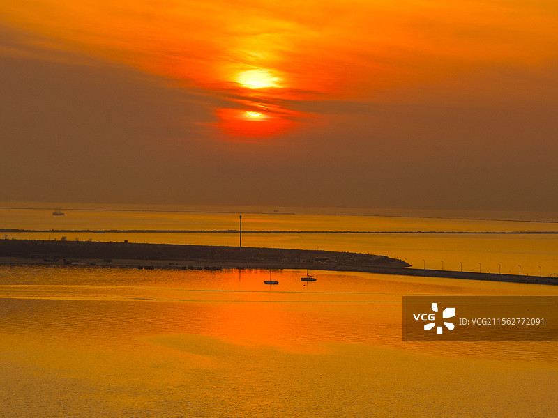 营口鲅鱼圈夕阳下海边沙滩日落夕阳下的大海图片素材