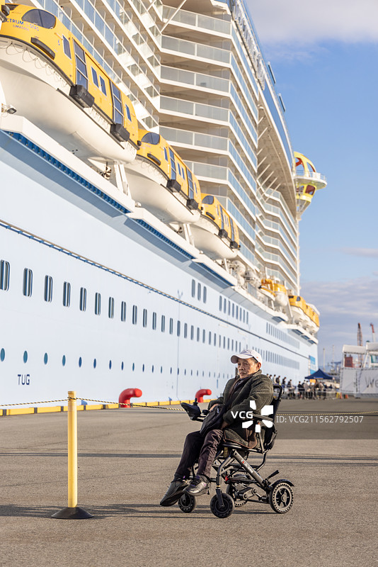 中国轮椅残疾老人与停靠在日本九州地区熊本八代港的海洋光谱号邮轮合影打卡图片素材
