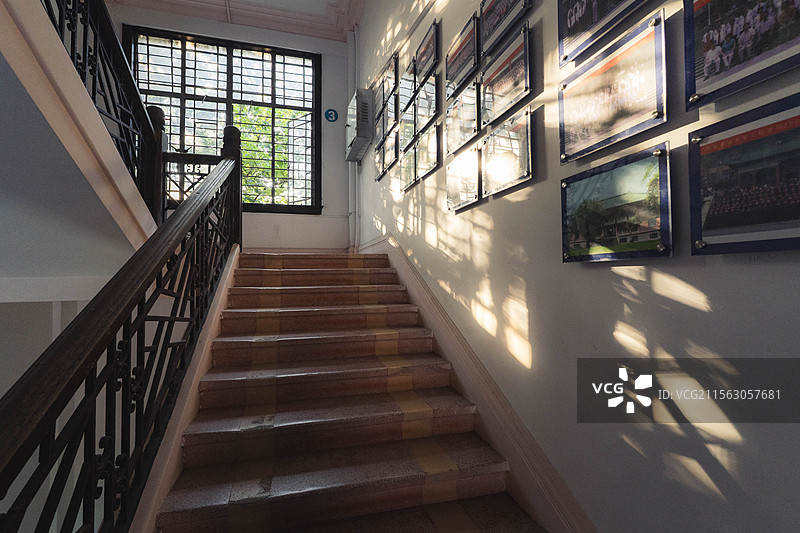 温暖阳光透过窗户照射到学校楼梯的照片墙上图片素材