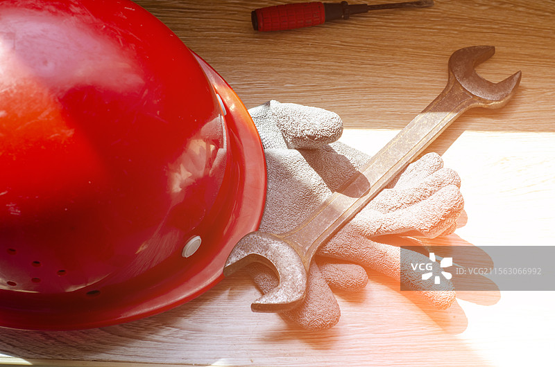 木板上的安全帽、扳手和手套等工作装备图片素材