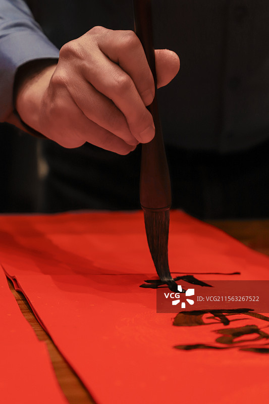 毛笔书写春联特写镜头-中国传统民俗和书法文化瞬间图片素材