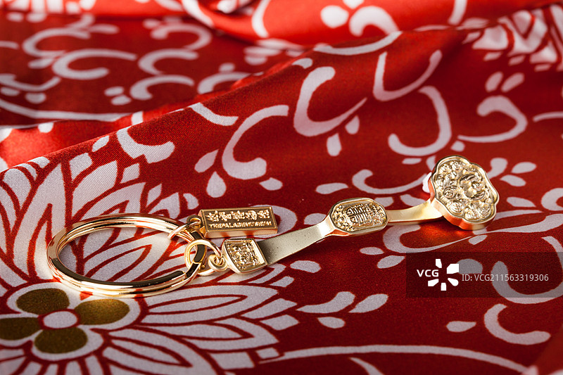 红绸缎上的金色钥匙链图片素材