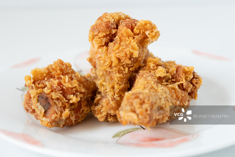 4个油炸辣鸡翅根美食小吃摆在陶瓷碟子上图片素材