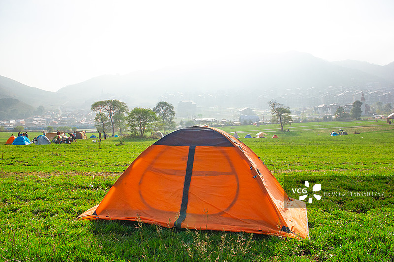 清晨山谷草坪上的露营帐篷图片素材