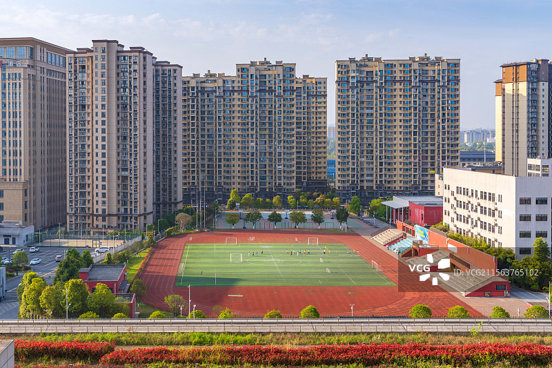 学校操场上一群踢足球的孩子图片素材