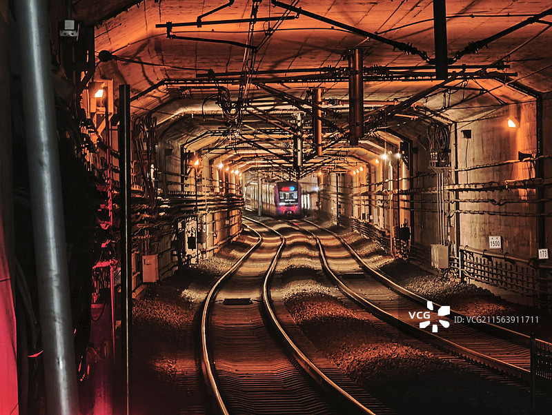 地铁站中离去的地铁与暖色调灯光图片素材