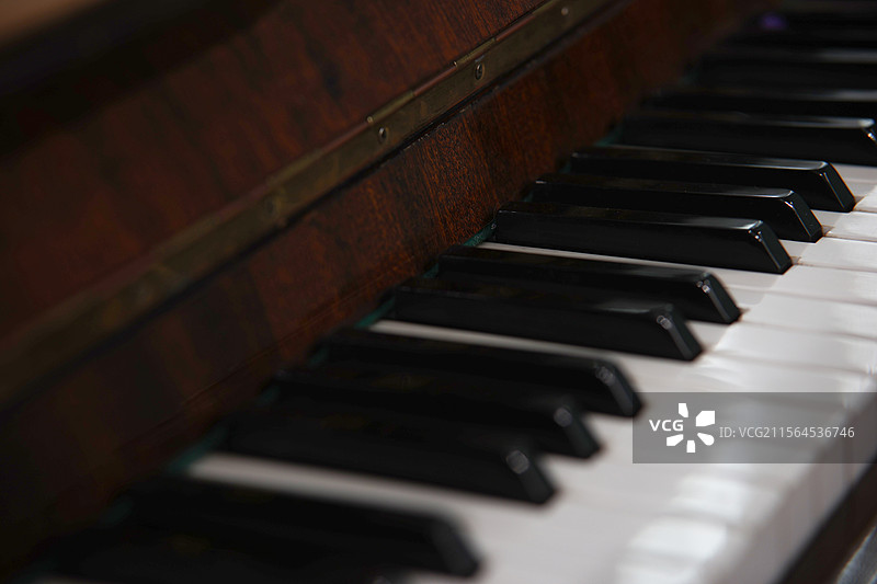 一架精致的木制钢琴，钢琴曲架上摆放着五线曲谱图片素材