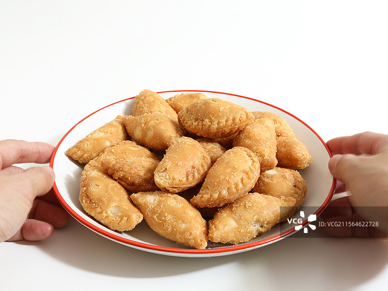 白色桌面上的一盘广东省潮汕特产美食三角酥图片素材