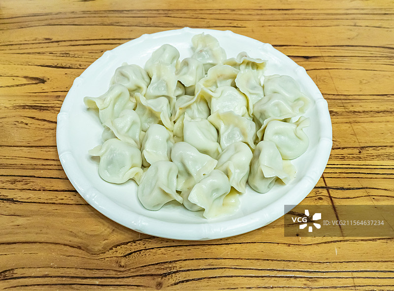 中国传统节日过年吃饺子拍摄主题，盘子盛着一碗热腾腾的水饺，室内无人图像摄影图片素材