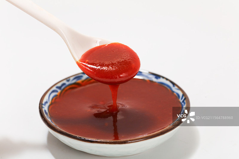 勺子里的辣椒酱往下滴落图片素材