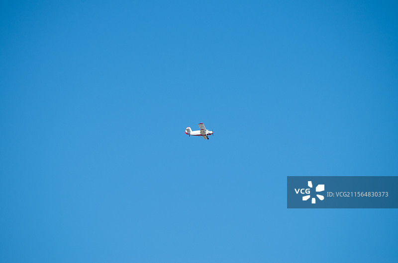 飞机在蓝天下飞行的低角度视图，户外自然风光，航空科技国防农业，军工运输交通图片素材