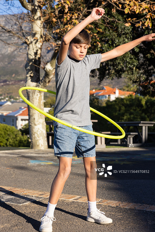 男孩在户外活动后玩呼啦圈，享受快乐时光图片素材