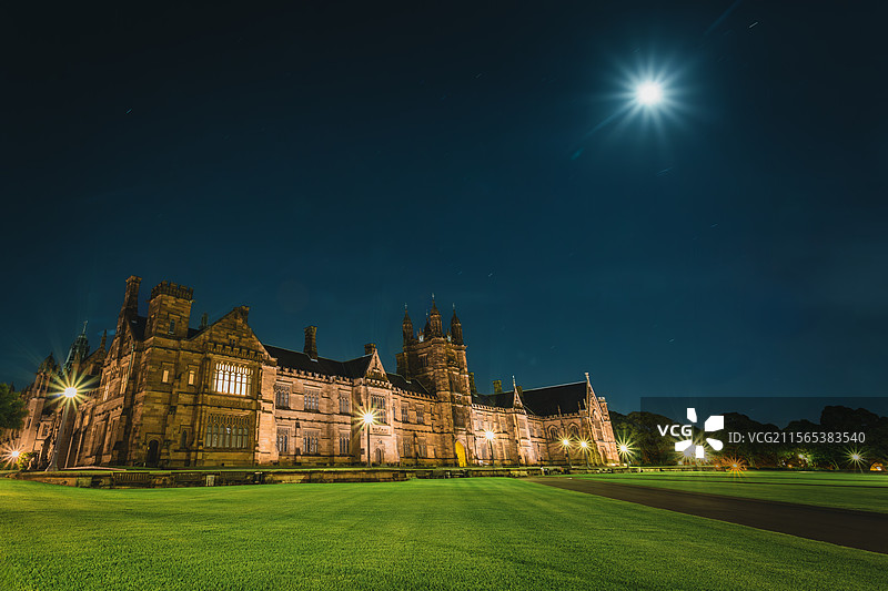 宁静与庄严的融合：月光下哥特式教堂映衬绿色草坪图片素材