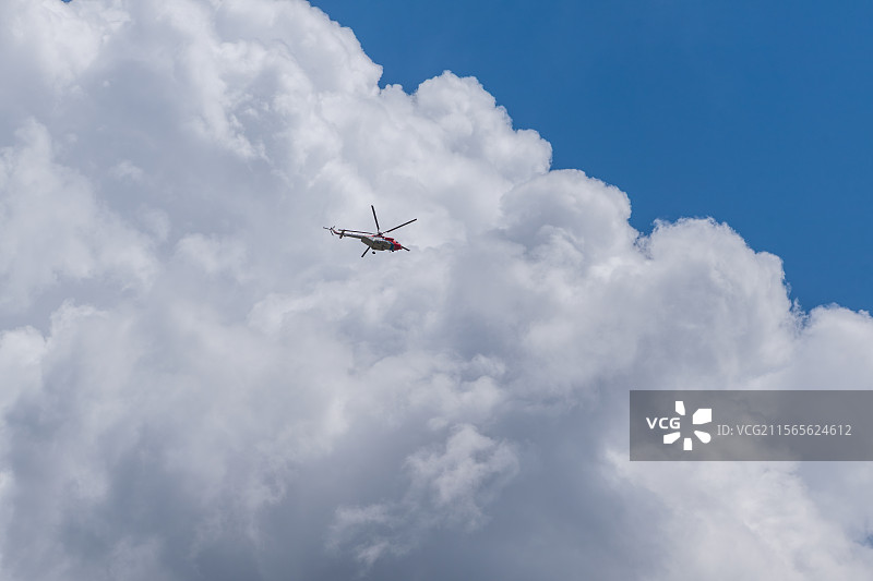 蓝天白云背景下的红色直升机图片素材